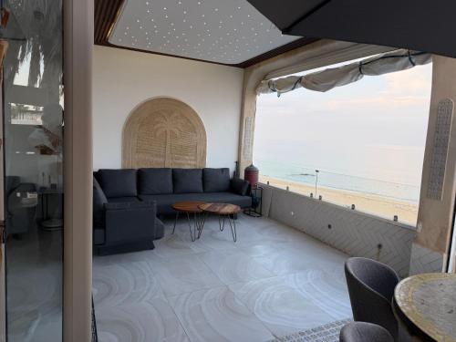 a living room with a couch and a view of the beach at Alamine plage in Fnidek