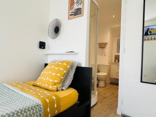 a bedroom with a bed and a yellow pillow at Chambre salle d'eau privée in Brest