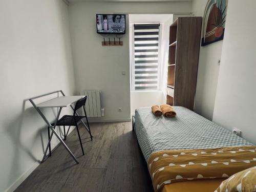 a bedroom with a bed and a table and a window at Chambre salle d'eau privée in Brest