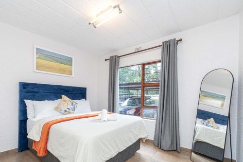 a bedroom with a bed and a mirror at 3 bed ground in sandton in Johannesburg