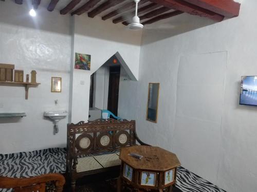 a room with a bed and a table in a room at Beiytul Noor Apartment in Lamu