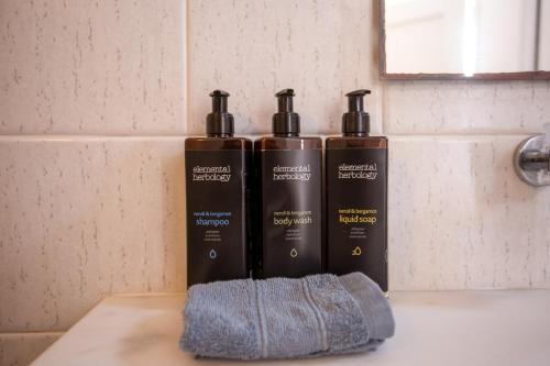 three bottles sitting on a counter in a bathroom at Yiannaki Hotel in Ornos