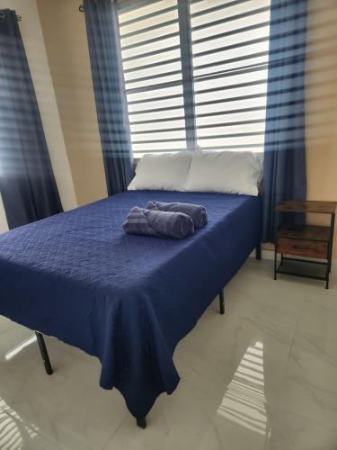 a blue bed with a towel on top of it at 2BR Apartment, Blue Ocean Suites, Manati in Manati