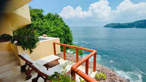 a balcony with two chairs and a view of the ocean at Espuma Hotel - Adults Only in Zihuatanejo