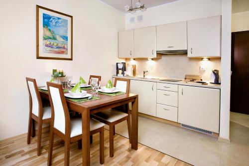a kitchen and dining room with a table and chairs at Apartament Aquamarina Międzyzdroje in Międzyzdroje