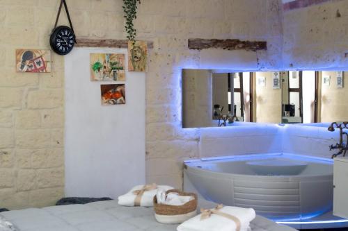 a bathroom with a tub and a mirror at QUART0 GREC0 Suite 17 in Altamura