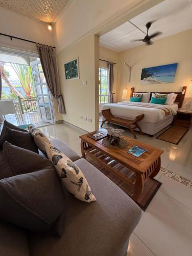 a living room with a bed and a couch at Maison Charme De L'ile in La Digue