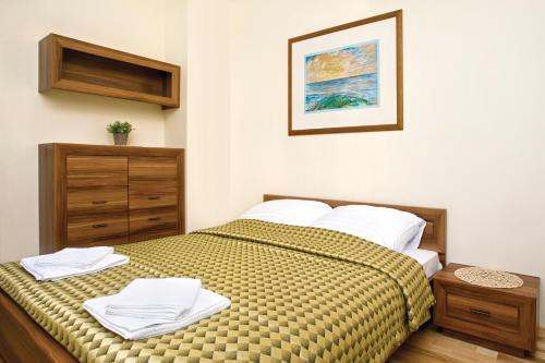 ミエンジズドロイェにあるApartament Aquamarina Międzyzdrojeのベッドルーム1室(ベッド1台、白いタオル付)