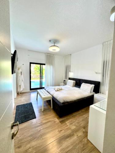 a bedroom with a large bed and a bathroom at Villa Casa Blanca in Kefar H̱ananya