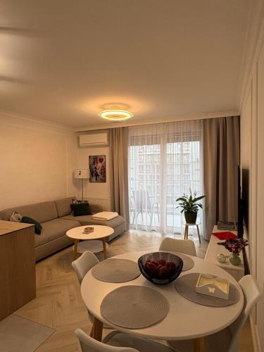 a living room with a couch and a table and chairs at Luksusowy Apartament Onyks - Parking Gratis in Suwałki