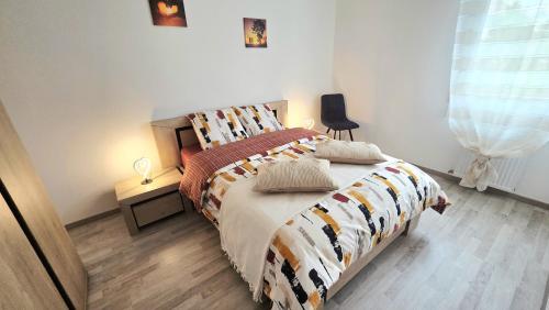 a bedroom with a bed with a comforter on it at L'appartement de Maya in Saint-Priest