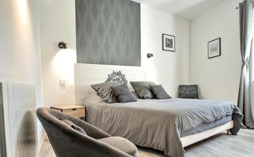 a bedroom with a bed and a chair at Domaine de la violette in Orange