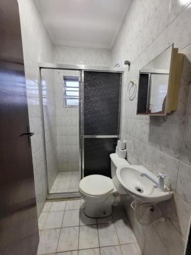a bathroom with a shower and a toilet and a sink at Cantinho do Mar in Bertioga