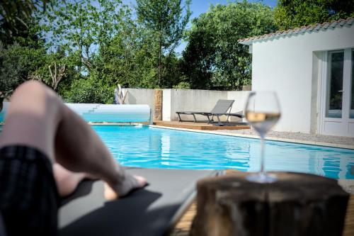 a person sitting on a table with a glass of wine at Domaine de la violette in Orange
