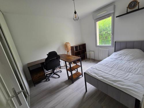a bedroom with a bed and a desk and a chair at Appartement à Nailloux in Nailloux
