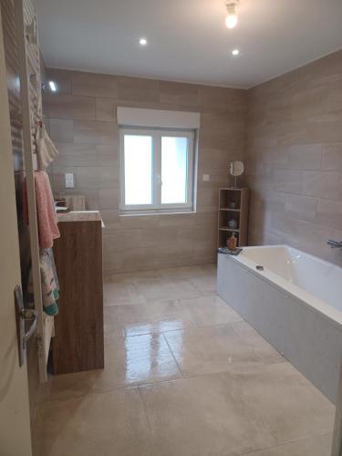 a large bathroom with a tub and a window at Chez Pépé in Limalonges