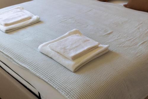 two white towels sitting on top of a bed at Apartment Solis 6 in Stara Novalja