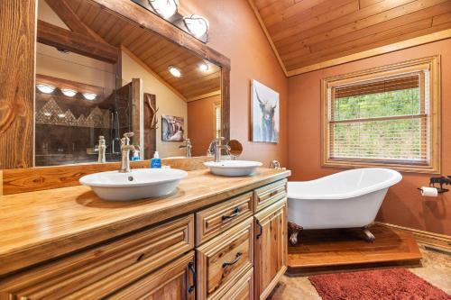 a bathroom with two sinks and a tub at Destiny Luxury Log Cabin in Sturgis