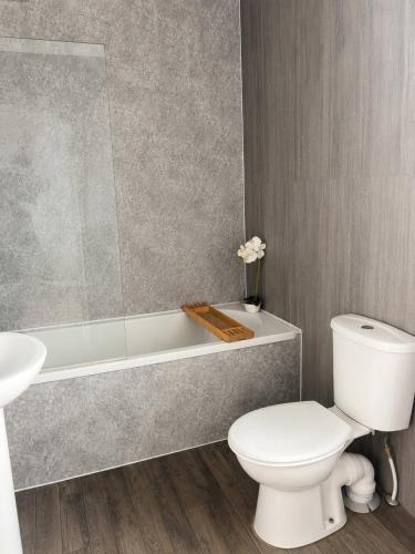 a bathroom with a white toilet and a bath tub at Modern 3BR Close to Durham Centre in Gilesgate