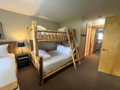 a bedroom with two bunk beds and a doorway at Timberline Lodges by Fernie Lodging Co in Fernie