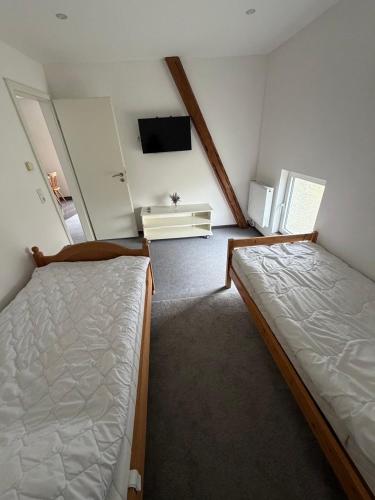a small room with two beds and a tv at Monteurzimmer\Ferienwohnung in Bad Gandersheim