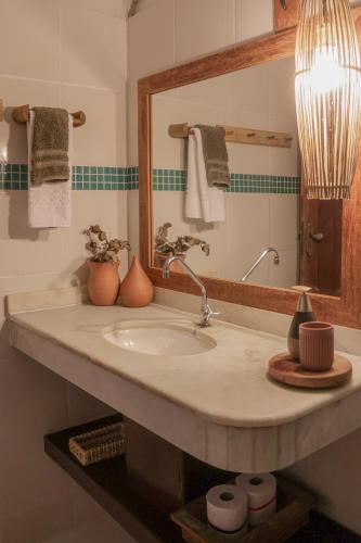 a bathroom with a sink and a mirror at Na Villa dos Algodões in Marau