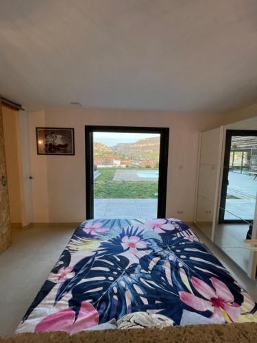 a bedroom with a bed with a large window at Villa Millau-gorges du Tarn in Aguessac