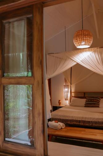 a bedroom with a canopy bed and a window at Na Villa dos Algodões in Marau