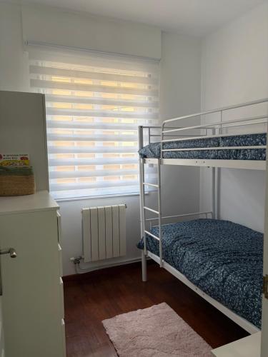 a bedroom with two bunk beds and a window at Apartamento Nordés in A Guarda