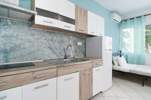 a kitchen with a sink and a refrigerator at Solere Apartments in Limenaria
