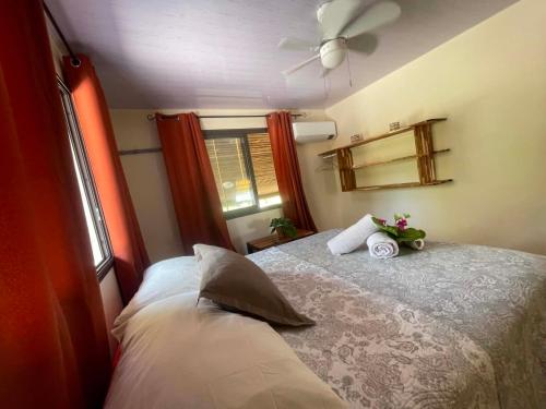 a bedroom with a bed with a fan and a window at Fare Te Vaite in Tikehau Airport
