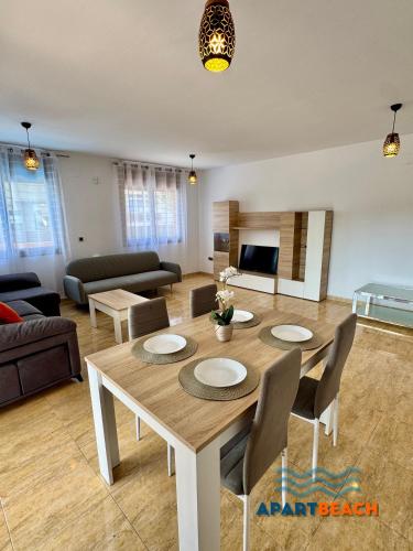 a living room with a wooden table and chairs at APARTBEACH BLAU MAR y PORT AVENTURA in Salou