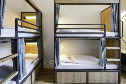 a room with three bunk beds in a hostel at Astor Victoria Hostel in London