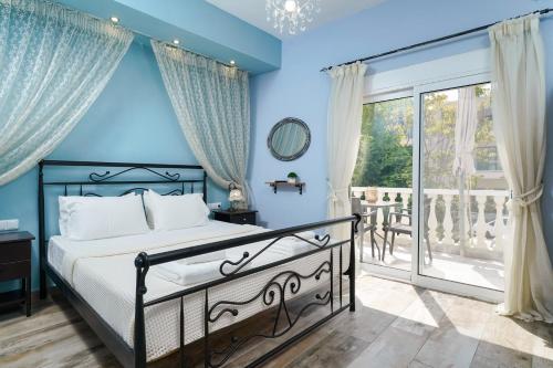 a blue bedroom with a bed and a balcony at Solere Apartments in Limenaria