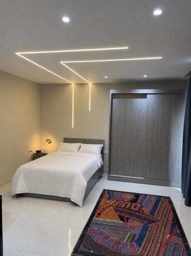 a bedroom with a large white bed and a rug at Modern Rooftop with Stunning View Iconic Tower in Madīnat aţ Ţalāʼi‘