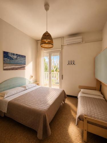a bedroom with a large bed and a window at Hotel Gianlore in Milano Marittima