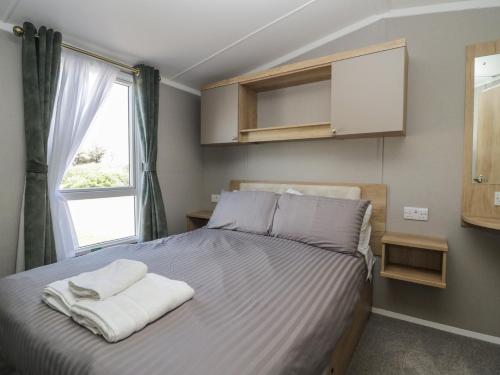 a bedroom with a bed with towels on it at The Swift in St Bees
