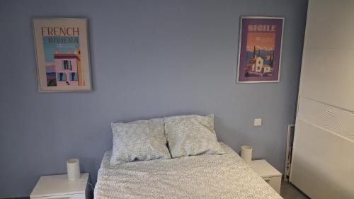 a bedroom with two posters on the wall and a bed at La benvingude CH d'hôte in Nyons