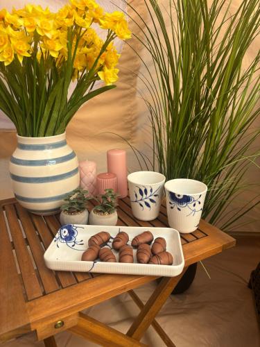 a tray of donuts on a table with vases and flowers at Fyn Glamping in Nyborg