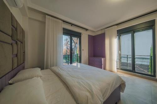 a bedroom with a large bed and large windows at Luku Villa in Sapanca