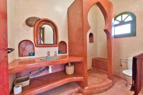 a bathroom with a wooden sink and a mirror at Villa Nouran - Chambre D'Hôte in Ghazoua