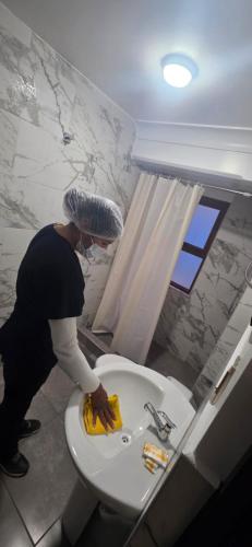 a woman standing next to a toilet in a bathroom at Hatun Wasi Puno in Puno
