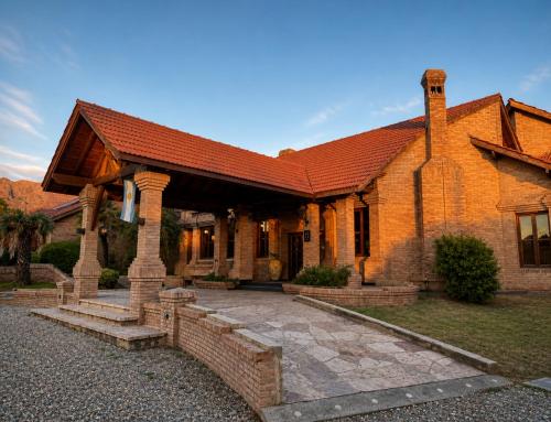 a large brick house with a red roof at Villa de Merlo All Inclusive & Spa by MH in Merlo