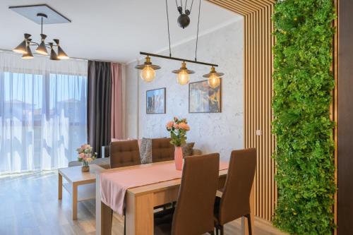 a dining room with a table and a green wall at Infinity View 3 Shkorpilovci in Shkorpilovtsi