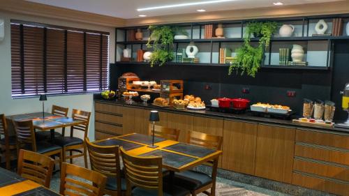 a restaurant with tables and chairs and a counter at Nohotel Nova Odessa in Nova Odessa