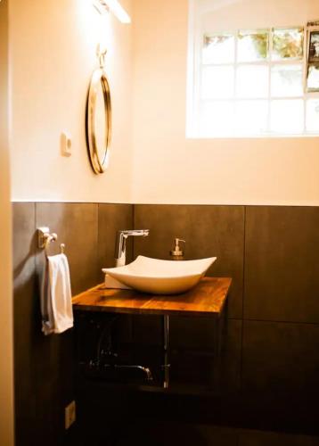 a bathroom with a white sink and a window at Zimmer auf Bauernhof in Kürten