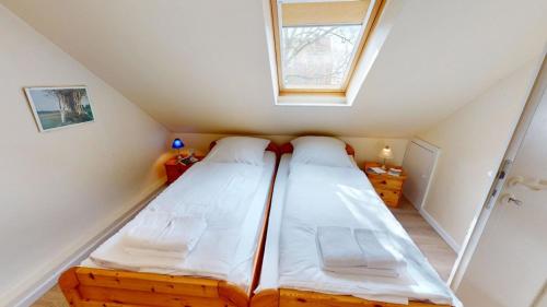 two beds in a small room with a window at Landhaus Gerdts - 1 in Cuxhaven
