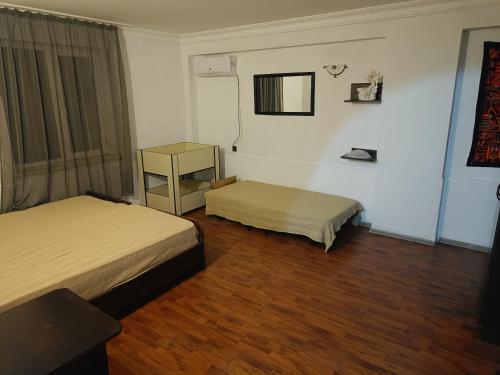 a bedroom with two beds and a wooden floor at Happy house in Kobuleti