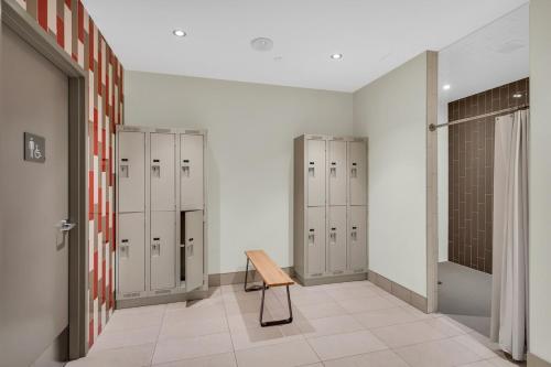 a locker room with three lockers and a wooden bench at Executive Condo with Parking DT Ottawa in Ottawa