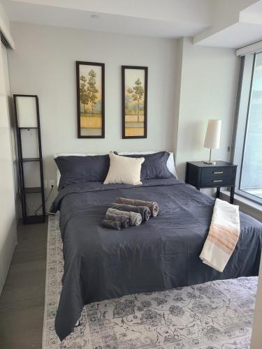a bedroom with a large bed with a blue blanket at Executive Condo with Parking DT Ottawa in Ottawa